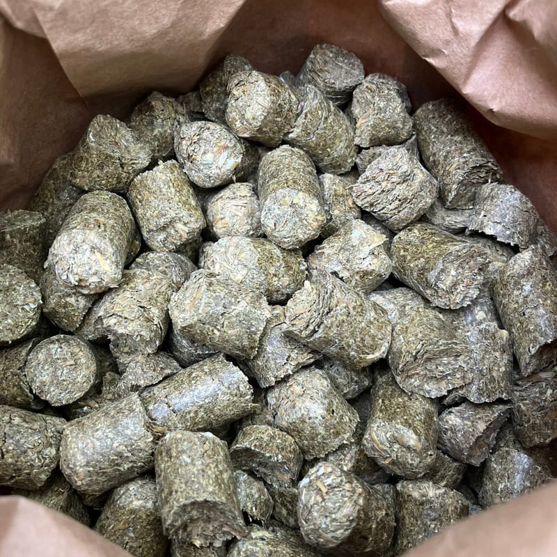 Blick in den geöffneten Papiersack COBS SONNE: gleichmäßig geformte Heucobs füllen den Sack bis zum Rand.